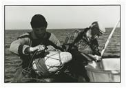 Pescador a " emboiar" cabaça e pescador a limpar pescado, a bordo da embarcação Estrela Divina