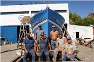 Fotografia de grupo dos proprietários e colaboradores do estaleiro naval Aquaplas junto com a embarcação Deus é Luz após a conclusão do trabalho de construção e reparação naval